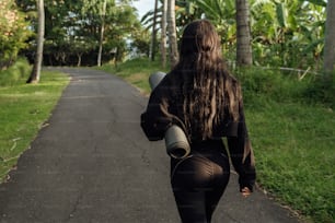 Una donna che cammina lungo una strada portando un barile