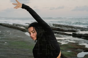 uma mulher fazendo uma pose de ioga na praia