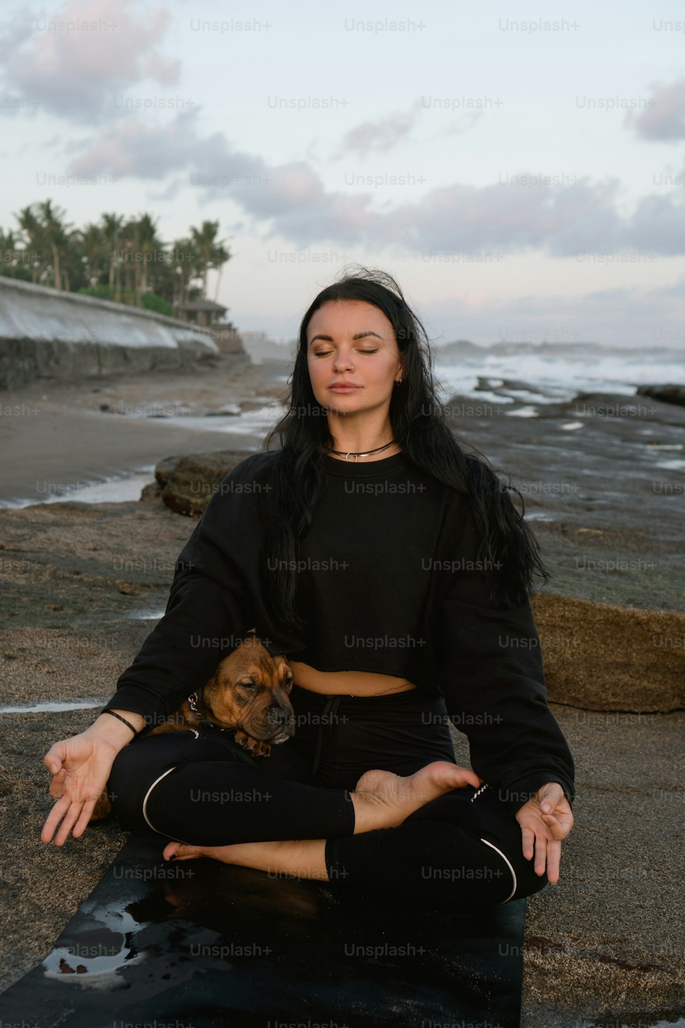 a woman sitting in a yoga pose with her dog