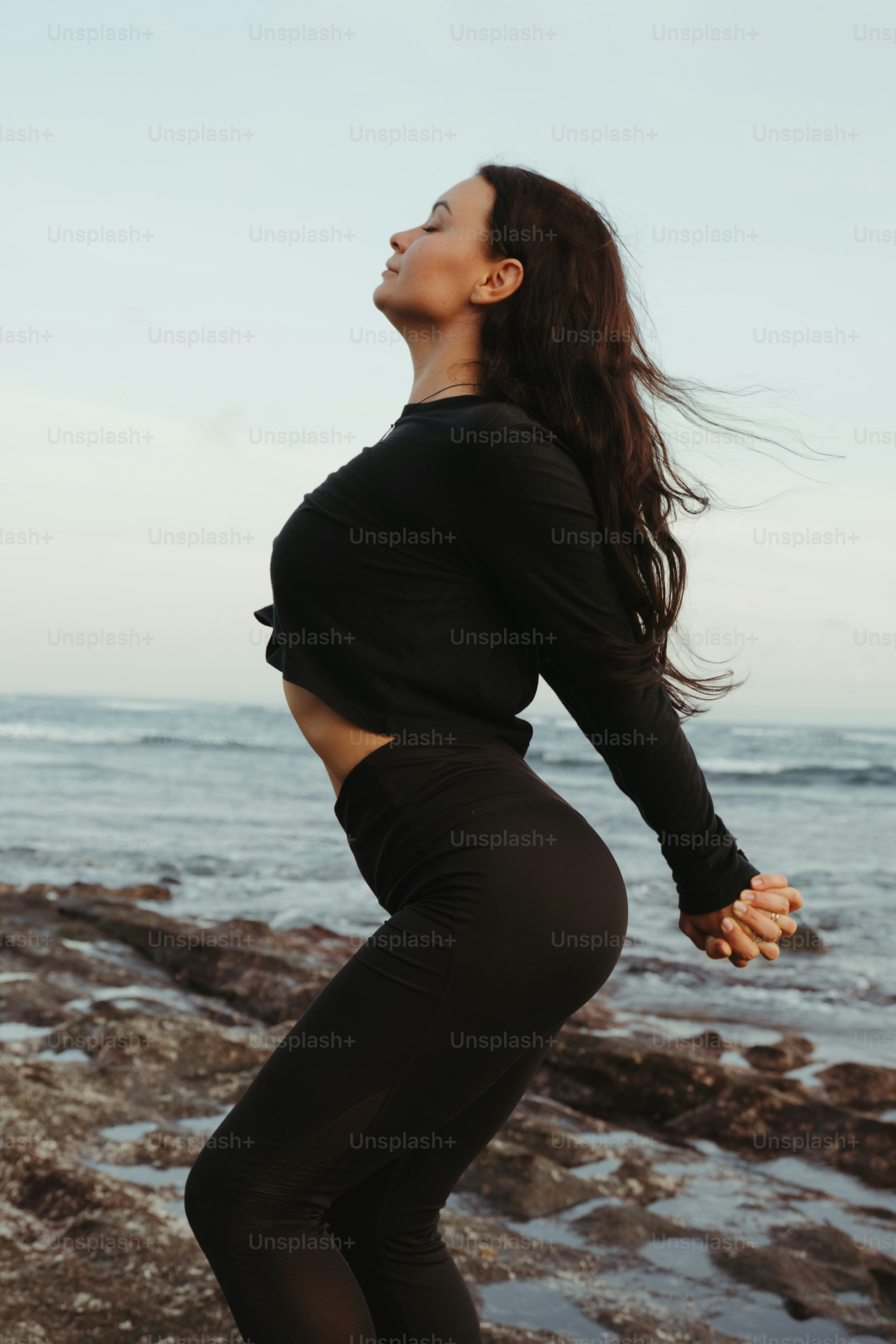 A woman standing on a rock near the ocean photo – People in nature ...