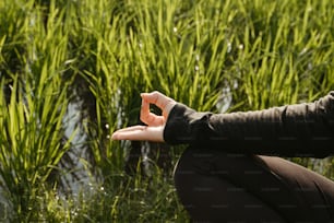 a woman kneeling down in front of a field of tall grass