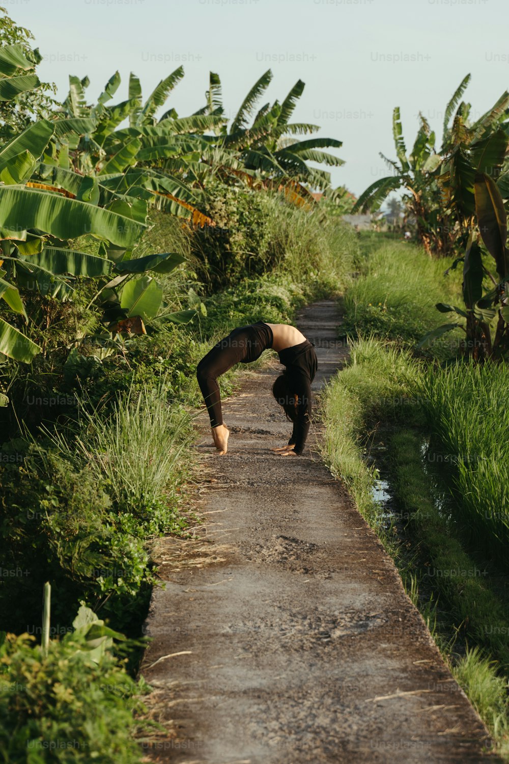 a person doing a handstand on a dirt road