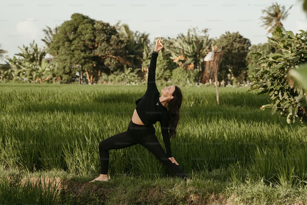 Una mujer haciendo yoga en un campo de hierba alta