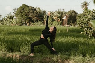 uma mulher fazendo yoga em um campo de grama alta