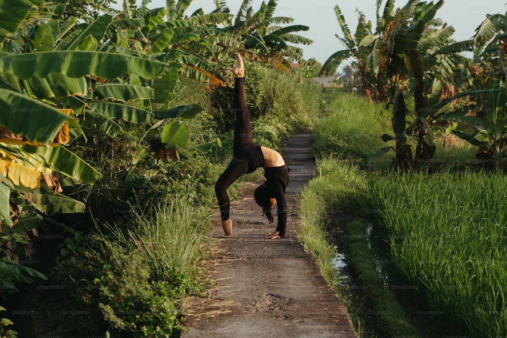 a person doing a handstand on a dirt road