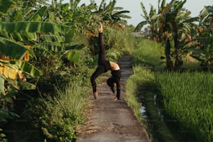 a person doing a handstand on a dirt road