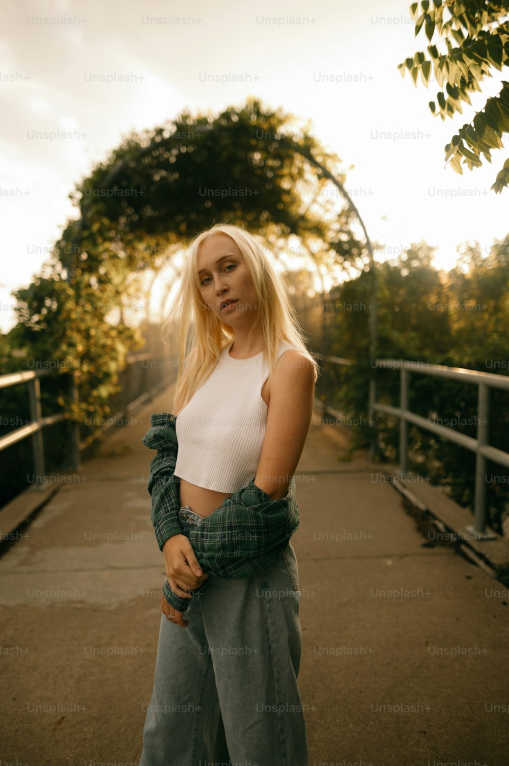 a woman standing on a bridge with her arms crossed