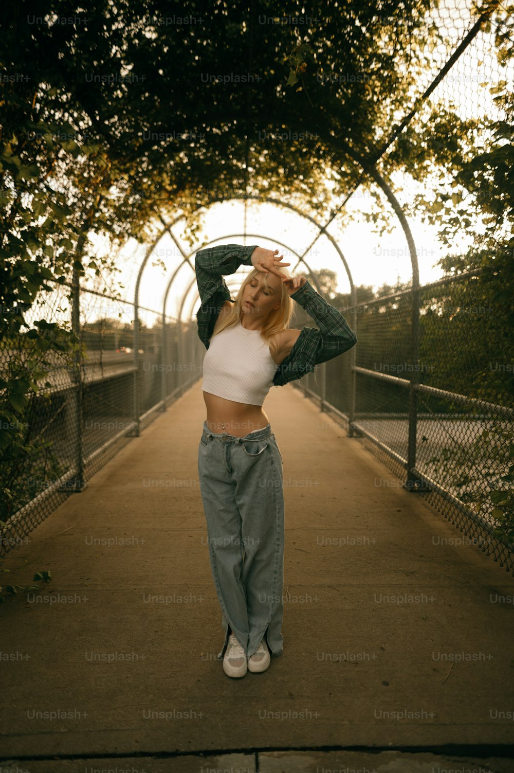 a woman standing on a bridge with her hands in her hair
