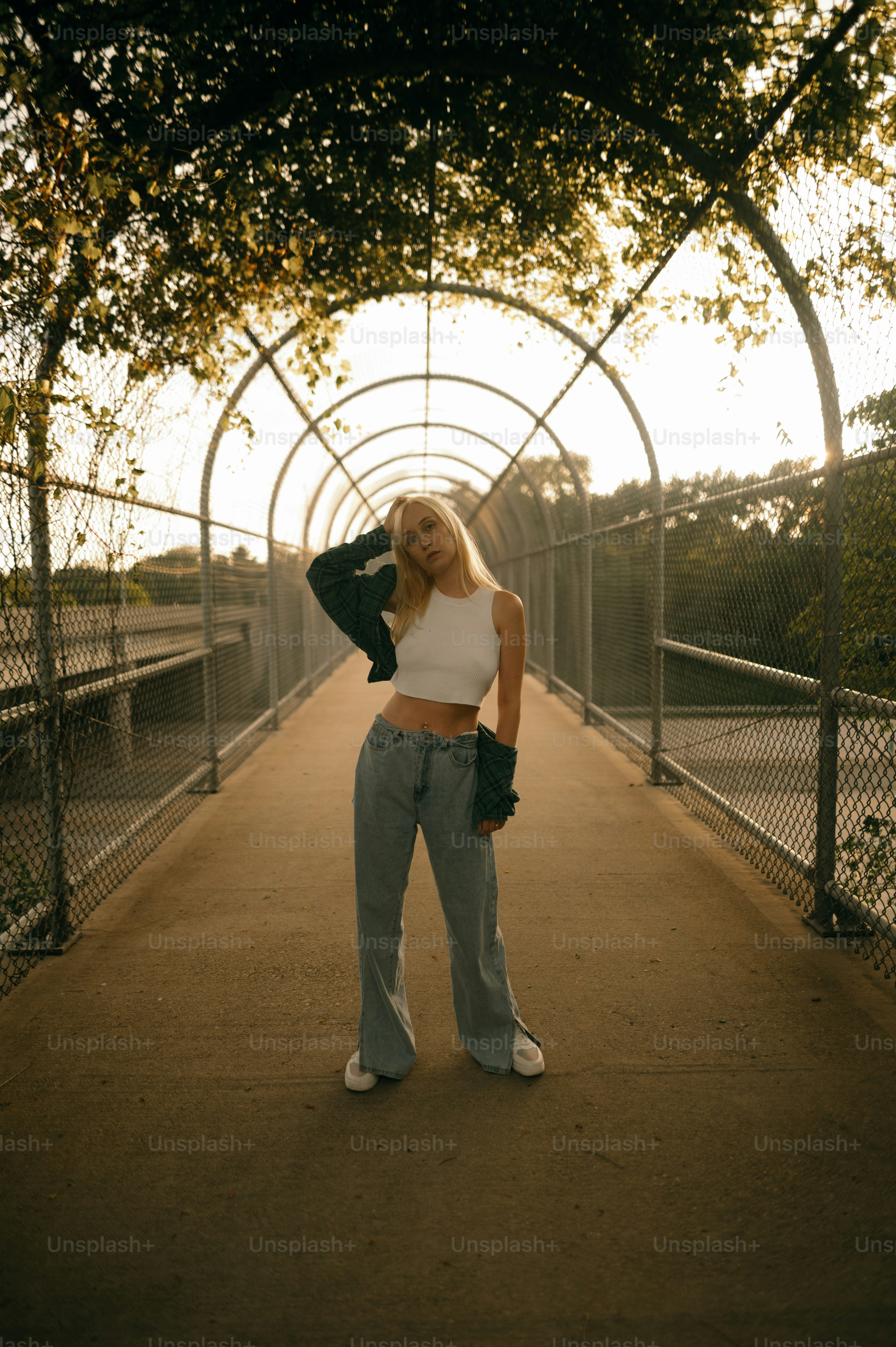 a woman standing on a bridge with her hands on her hips
