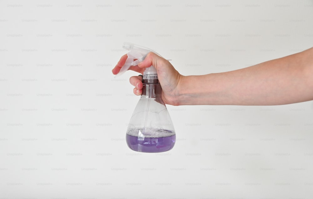 a person holding a purple substance in a flask