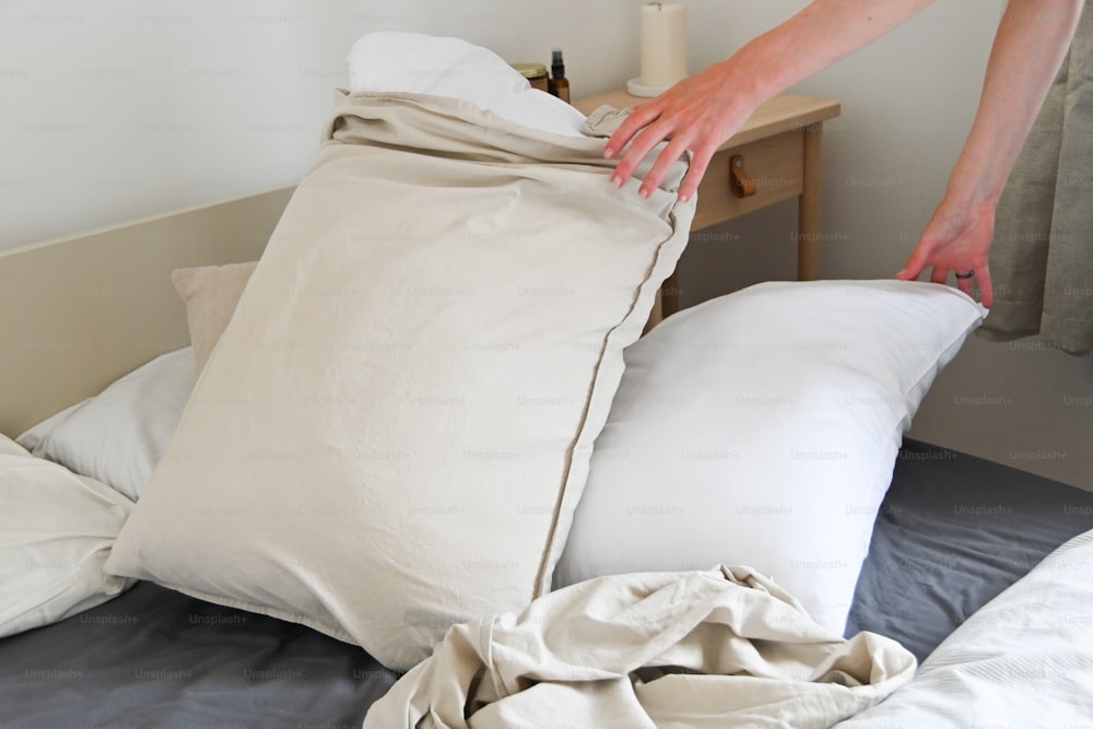 a person reaching for a pillow on a bed