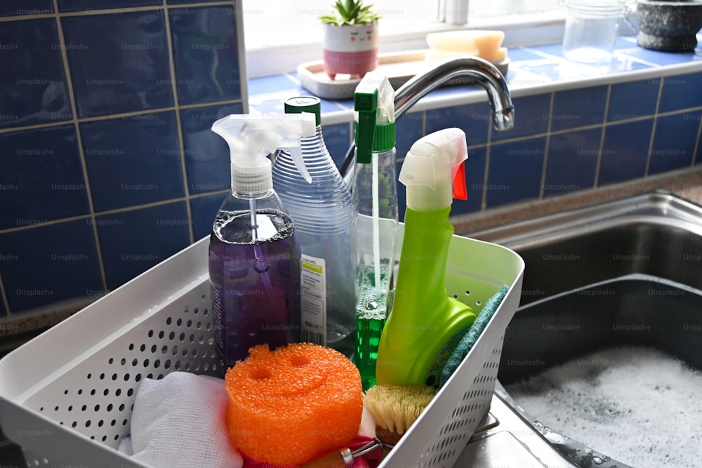 a sink filled with lots of cleaning supplies