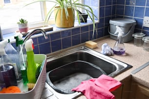 un lavello della cucina pieno di un sacco di prodotti per la pulizia