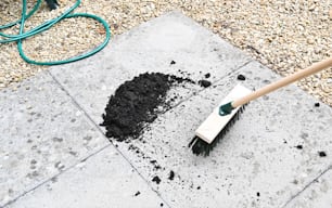 a shovel and a pile of dirt on a sidewalk