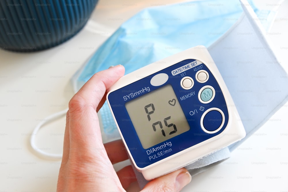 a person is holding a blood pressure meter