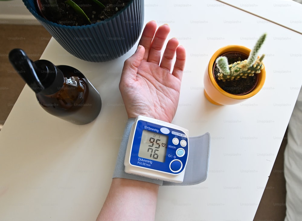 o braço de uma pessoa com um medidor de pressão arterial nele