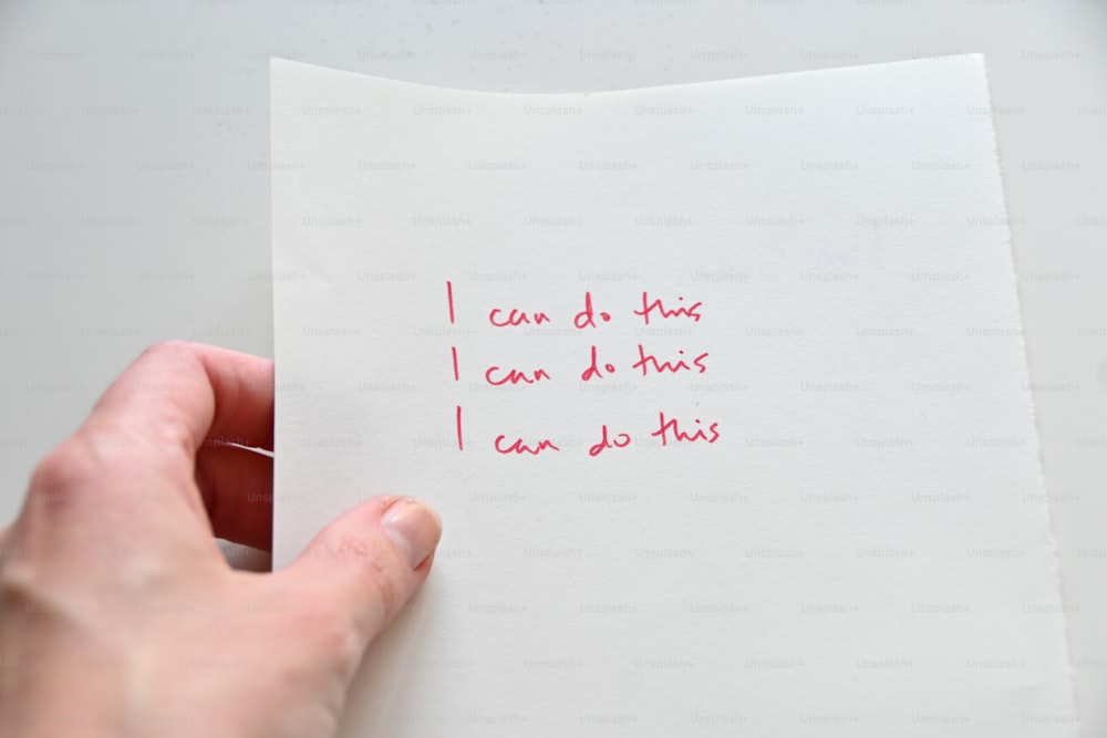 a person holding a piece of paper with writing on it