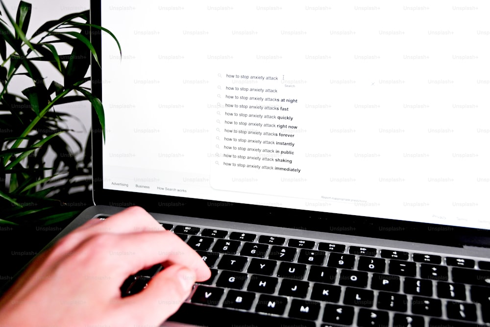 Una persona está escribiendo en el teclado de una computadora portátil