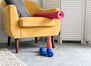 une chaise jaune avec un tapis rouge et deux cônes bleus sur le sol