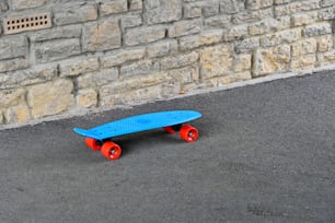 a blue skateboard sitting in front of a brick wall