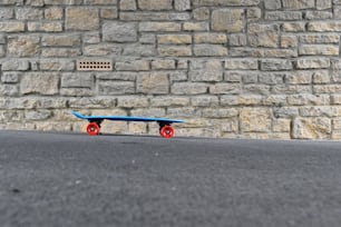 a blue skateboard sitting in front of a brick wall