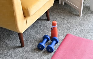 a pair of blue and orange dumbs sitting on the floor next to a yellow