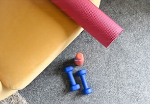 a pair of blue dumbs sitting on the floor next to a yoga mat