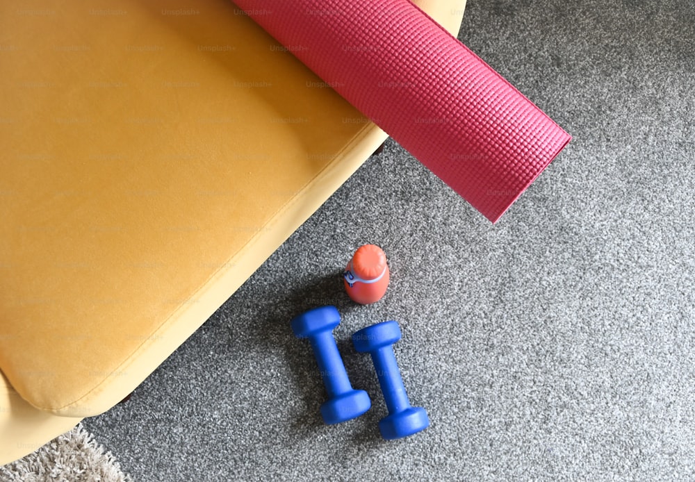 a pair of blue dumbs sitting on the floor next to a yoga mat