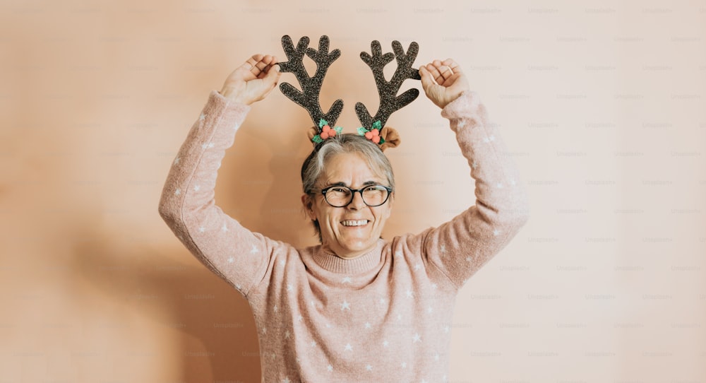 an older woman wearing reindeer antlers on her head