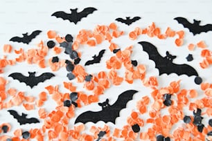 Una mesa blanca cubierta con muchos murciélagos naranjas y negros