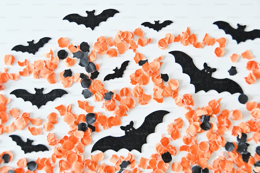 a white table topped with lots of orange and black bats