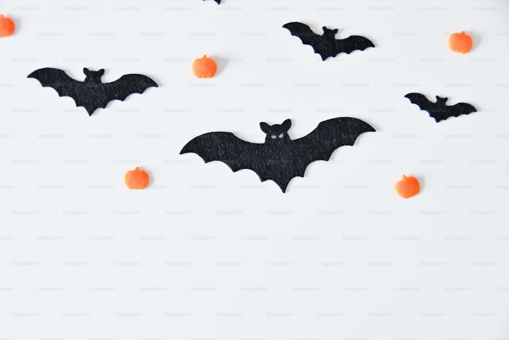 a white table topped with black bats and orange balls