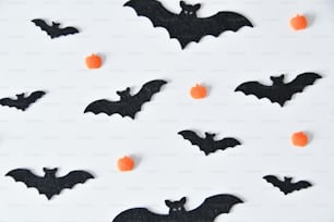 a white plate topped with black bats and orange candies