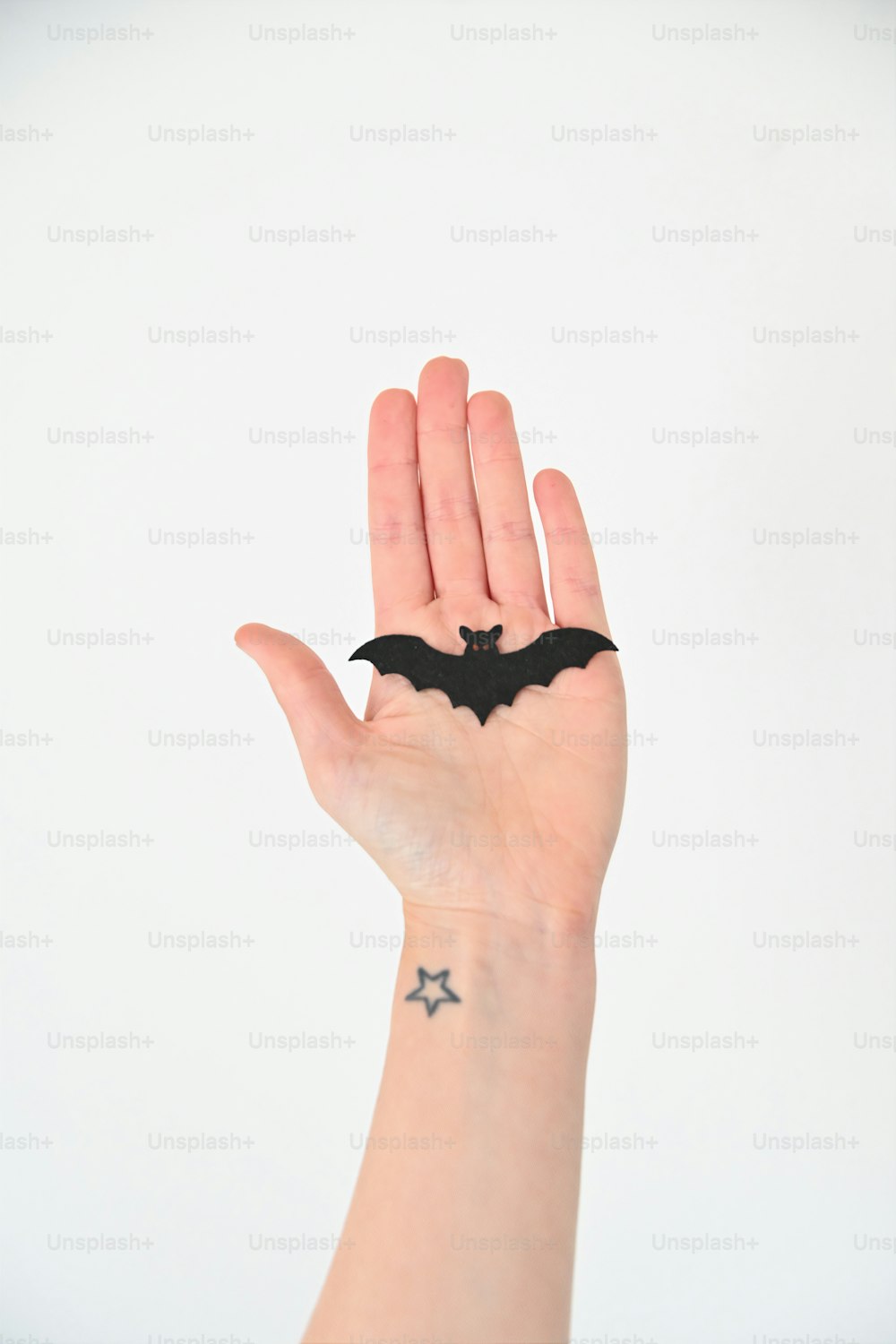 a person's hand with a bat tattoo on it