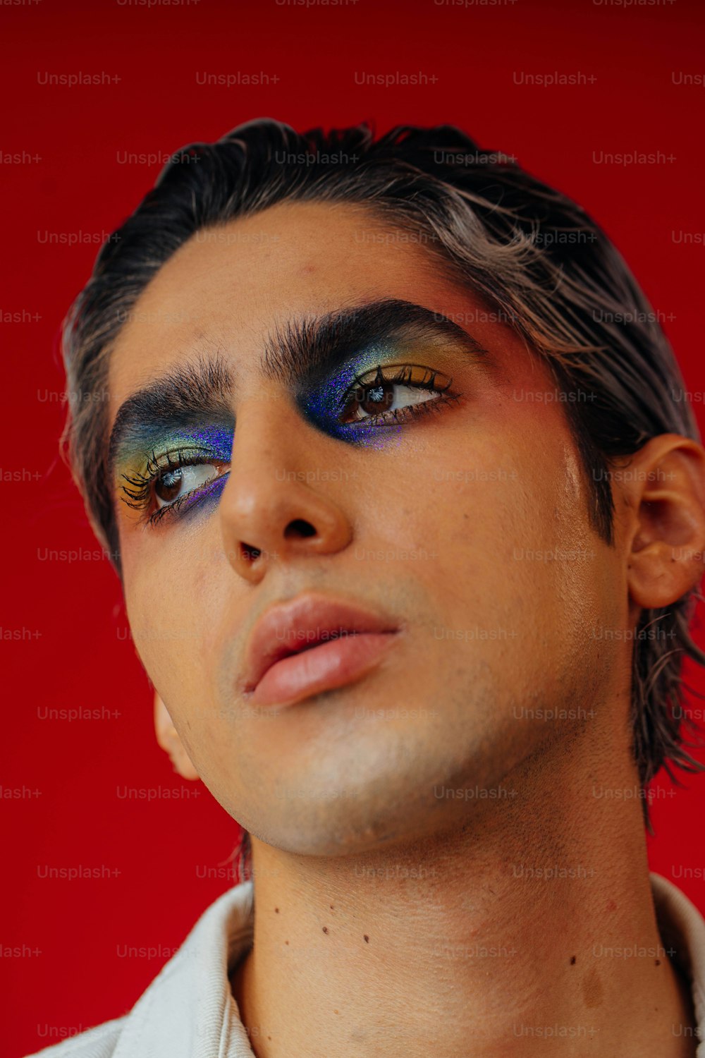 a man with blue and green eye makeup