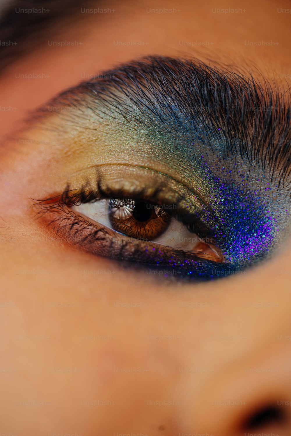 a close up of a person's eye with a blue and green eye shadow