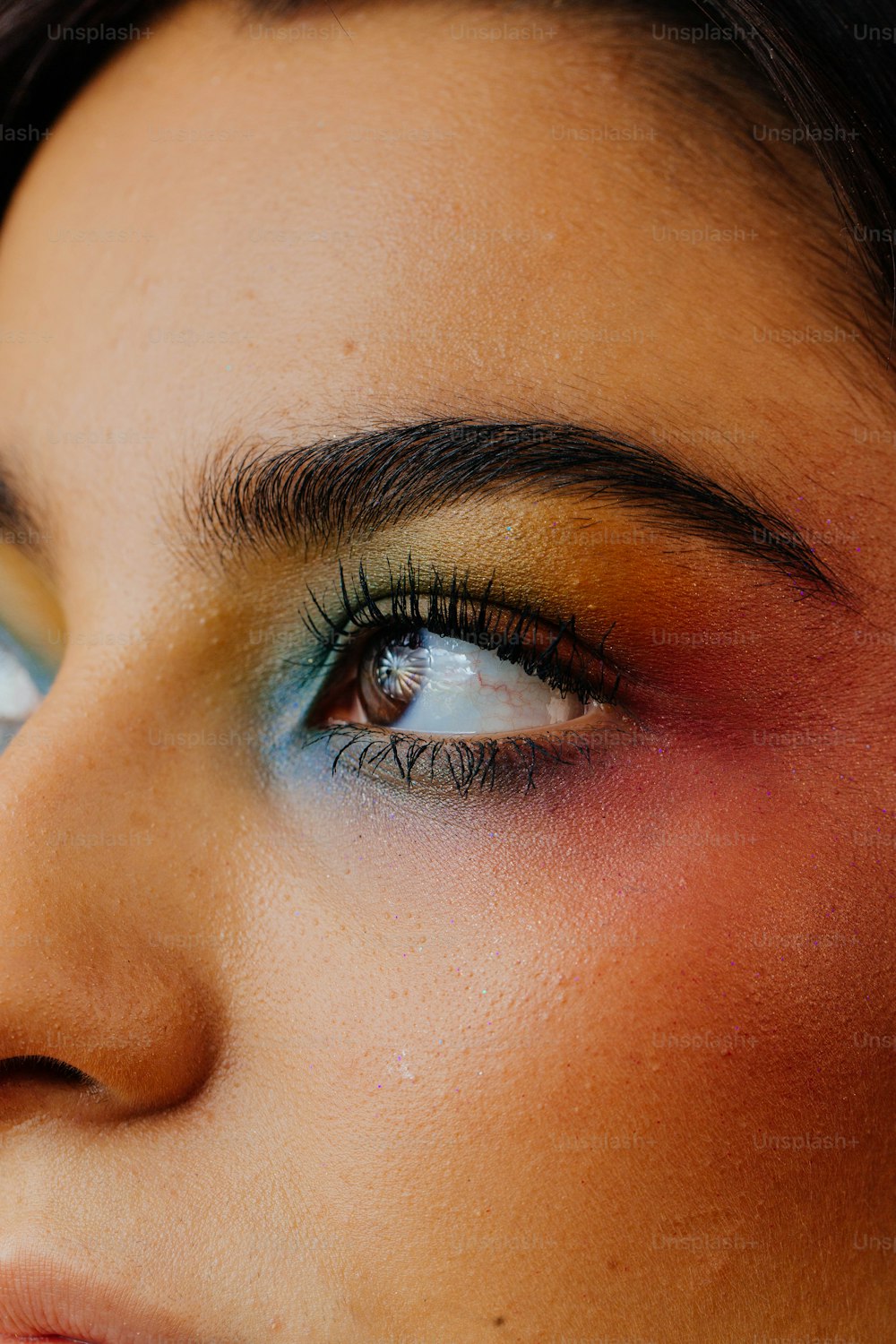 a close up of a woman's face with bright makeup
