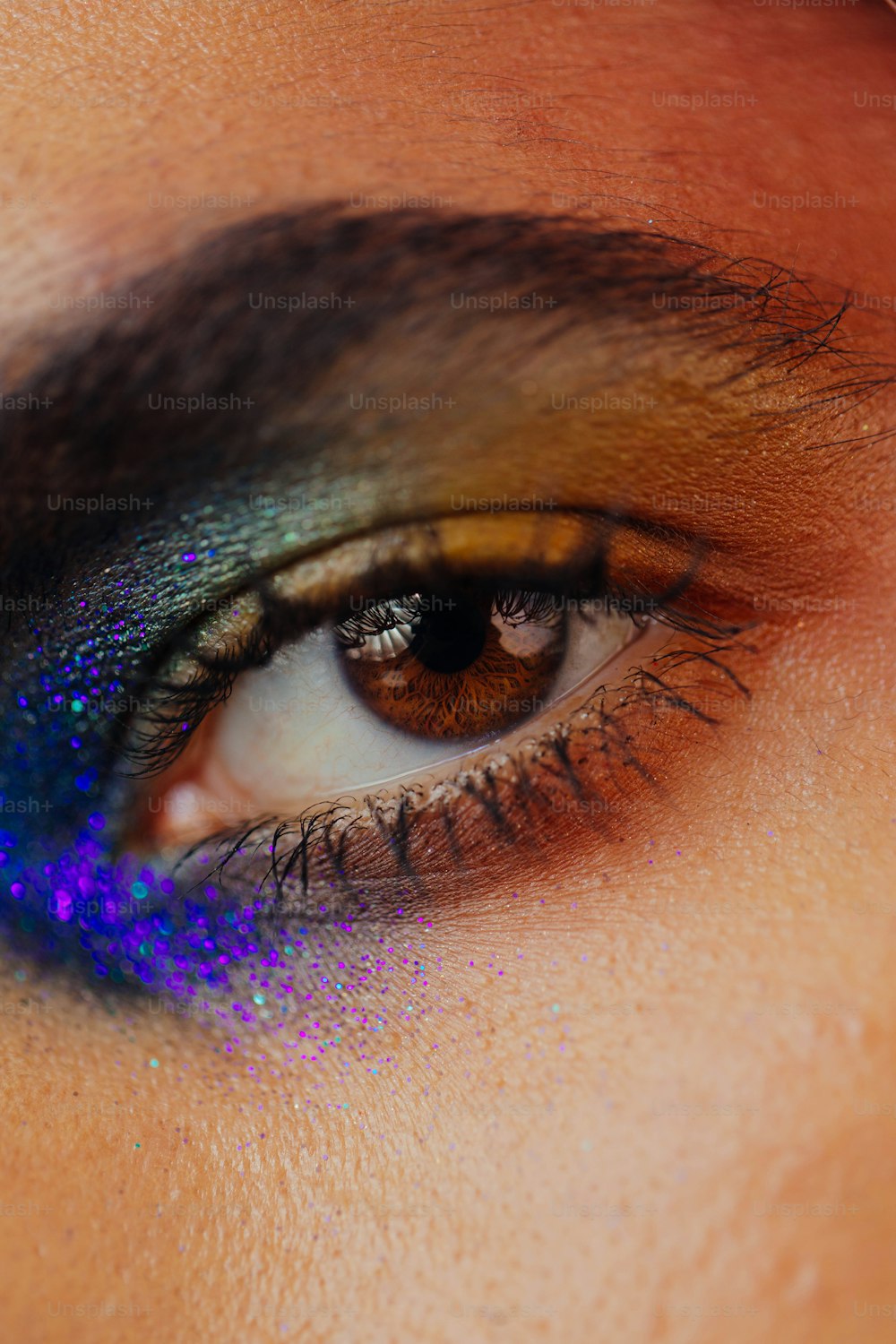 a close up of a person's eye with a blue and purple eye shadow