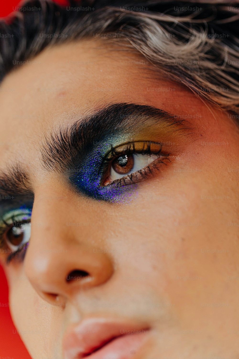 a close up of a person with blue and yellow eye makeup