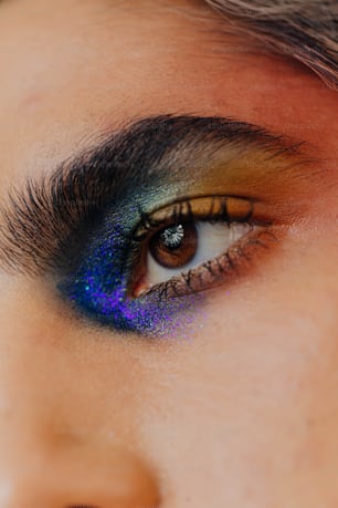 a close up of a person's eye with a blue and yellow eye shadow
