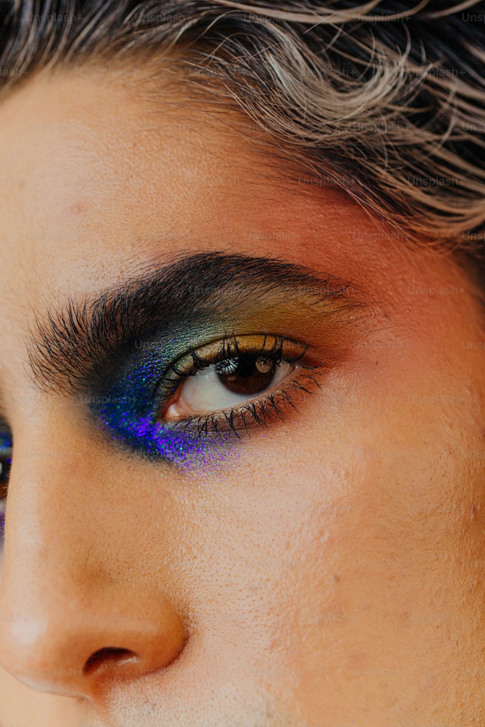 a close up of a person with a blue and purple eye shadow