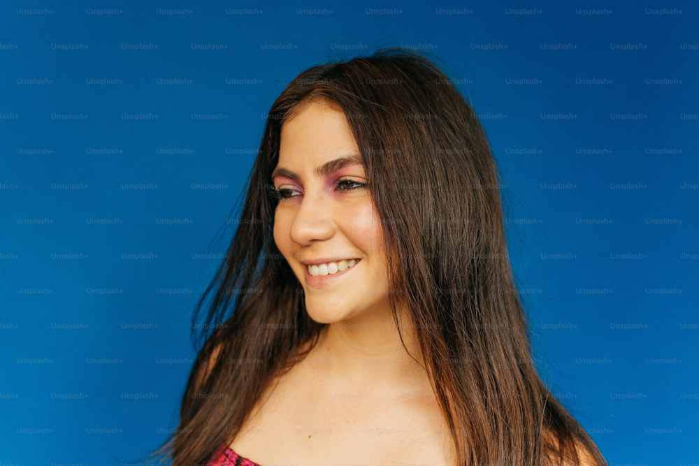 a woman with long brown hair smiling at the camera