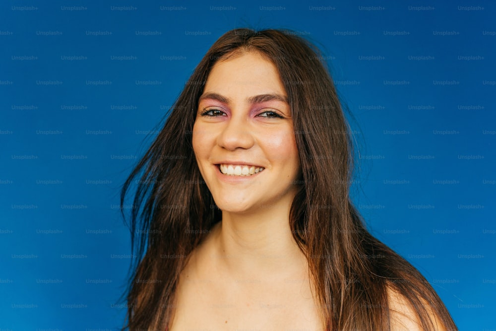 a woman with long brown hair smiling at the camera