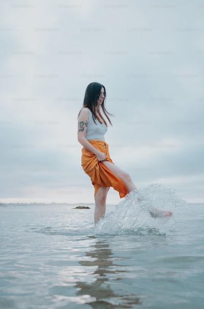 足を宙に浮かせて水の中に立っている女性の写真 – Unsplashの女性の画像