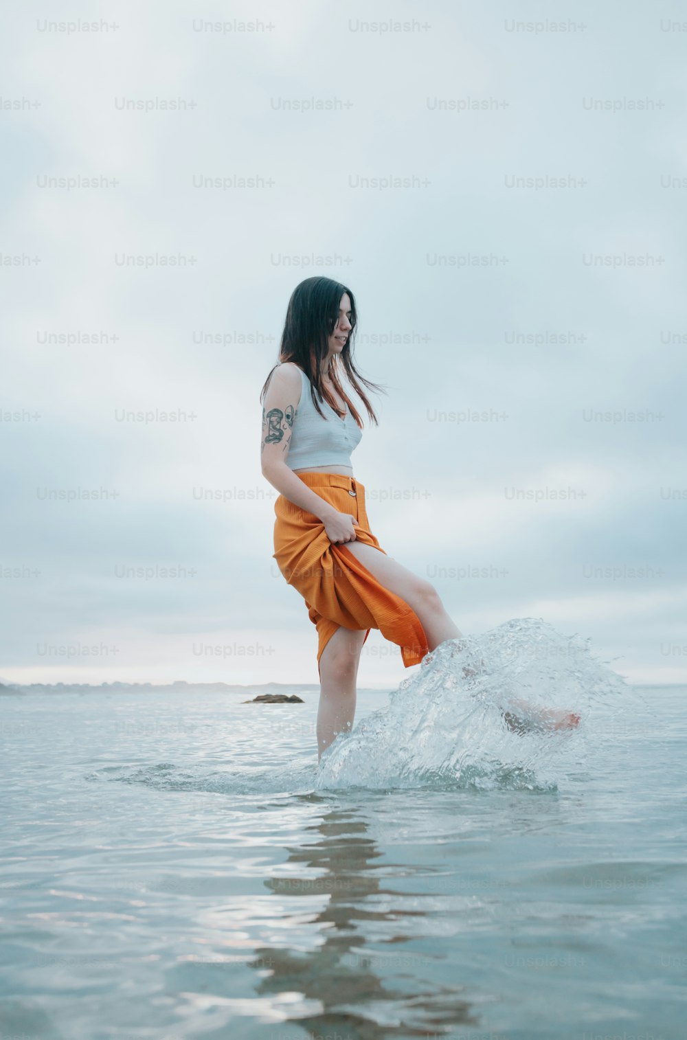 a woman standing in the water with her legs in the air