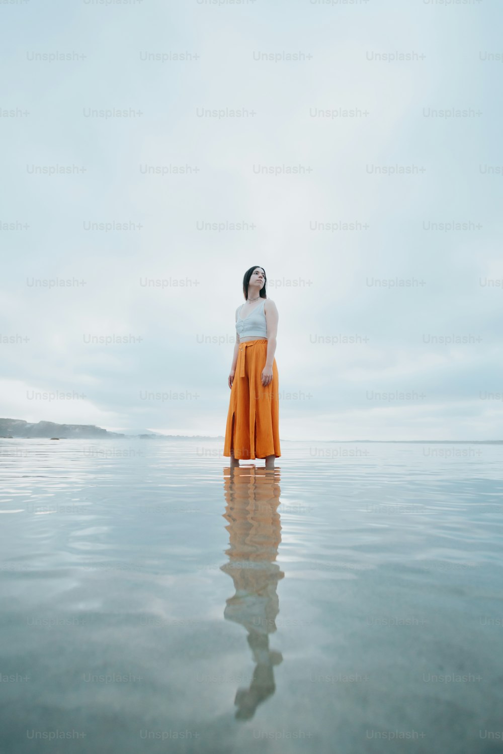 a woman standing in the middle of a body of water