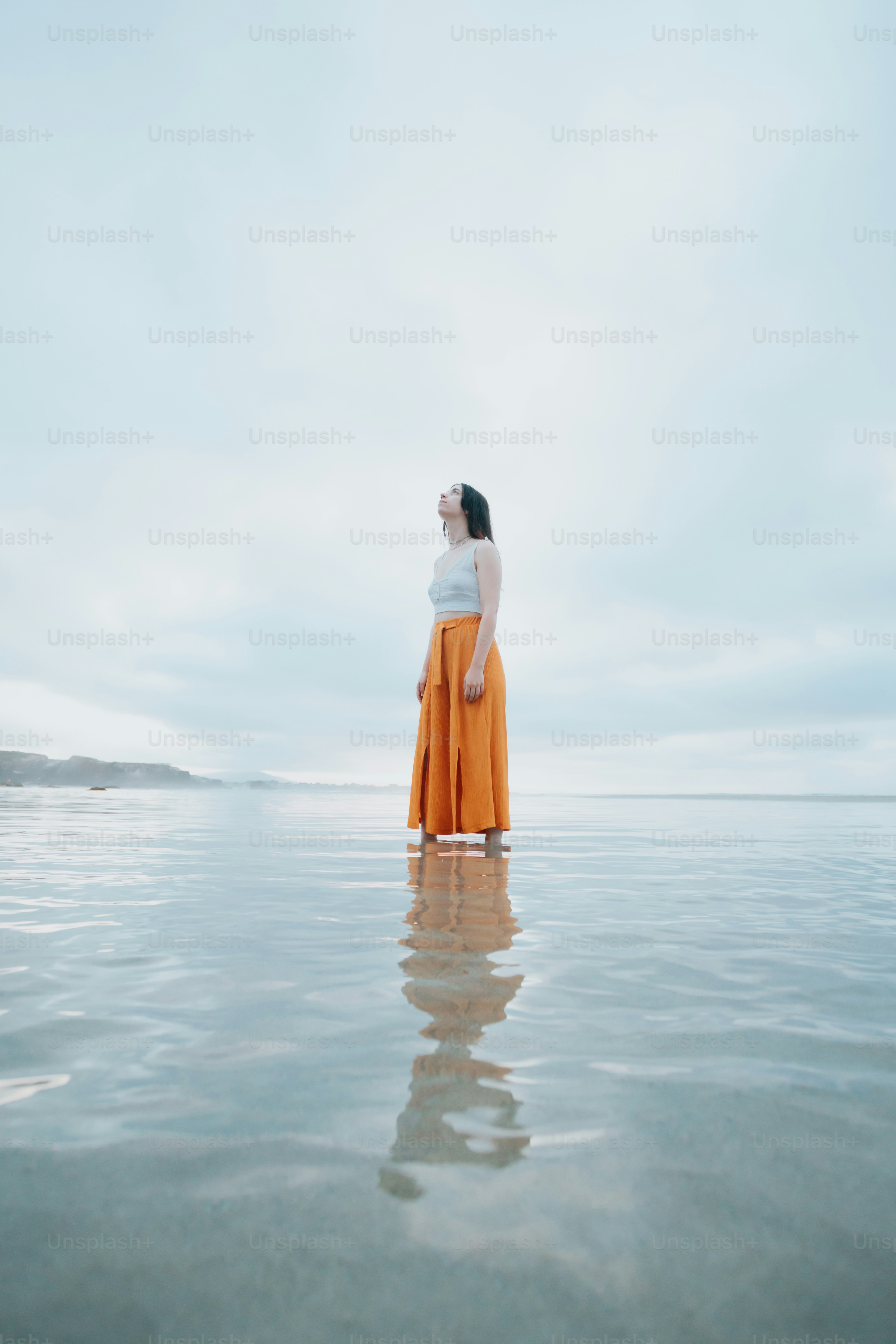 a woman standing in the middle of a body of water