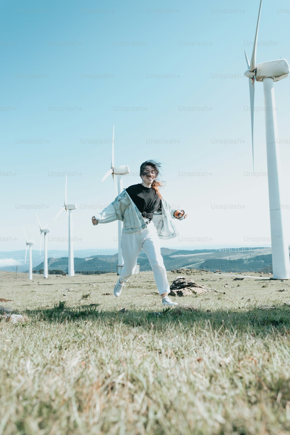 a man is running in a field of wind turbines