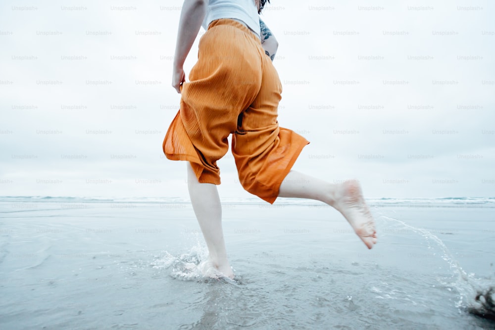 a person is running in the water on a beach