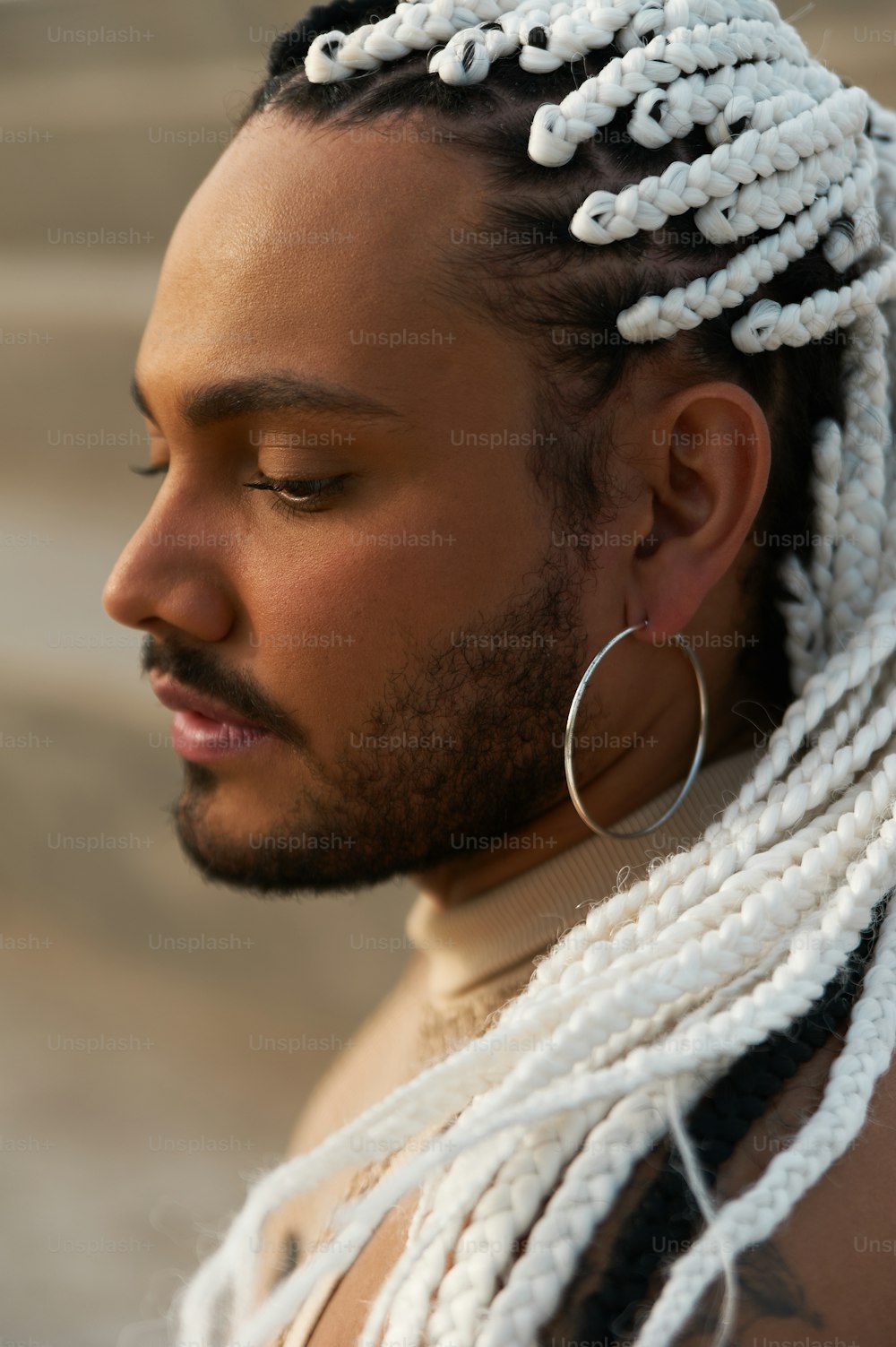 a man with dreadlocks and a hoop earring